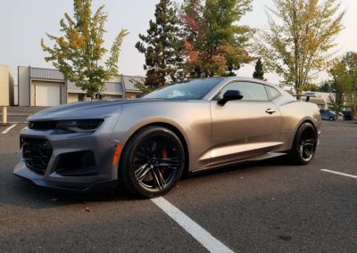 A charcoal grey chevy camaro ZL1 parked outside